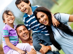 Mother and father with their son and daughter laughing and having fun