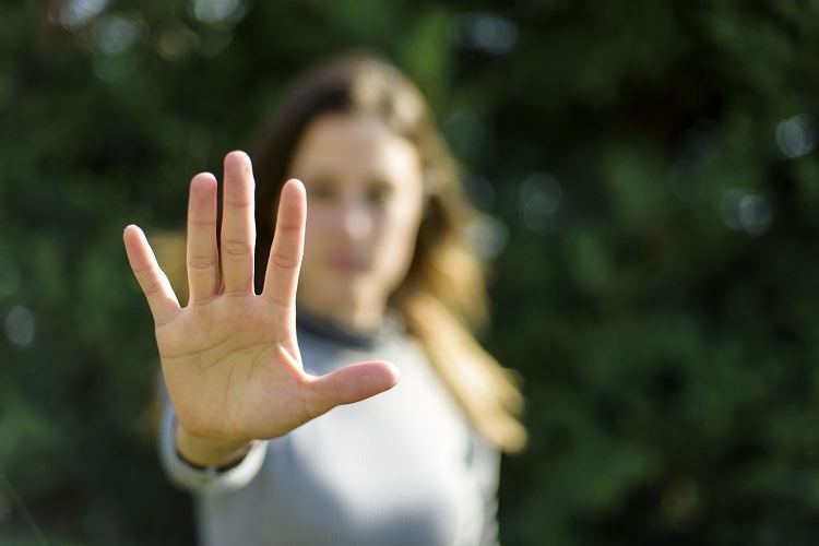 woman holding up her hand as a sign to stop